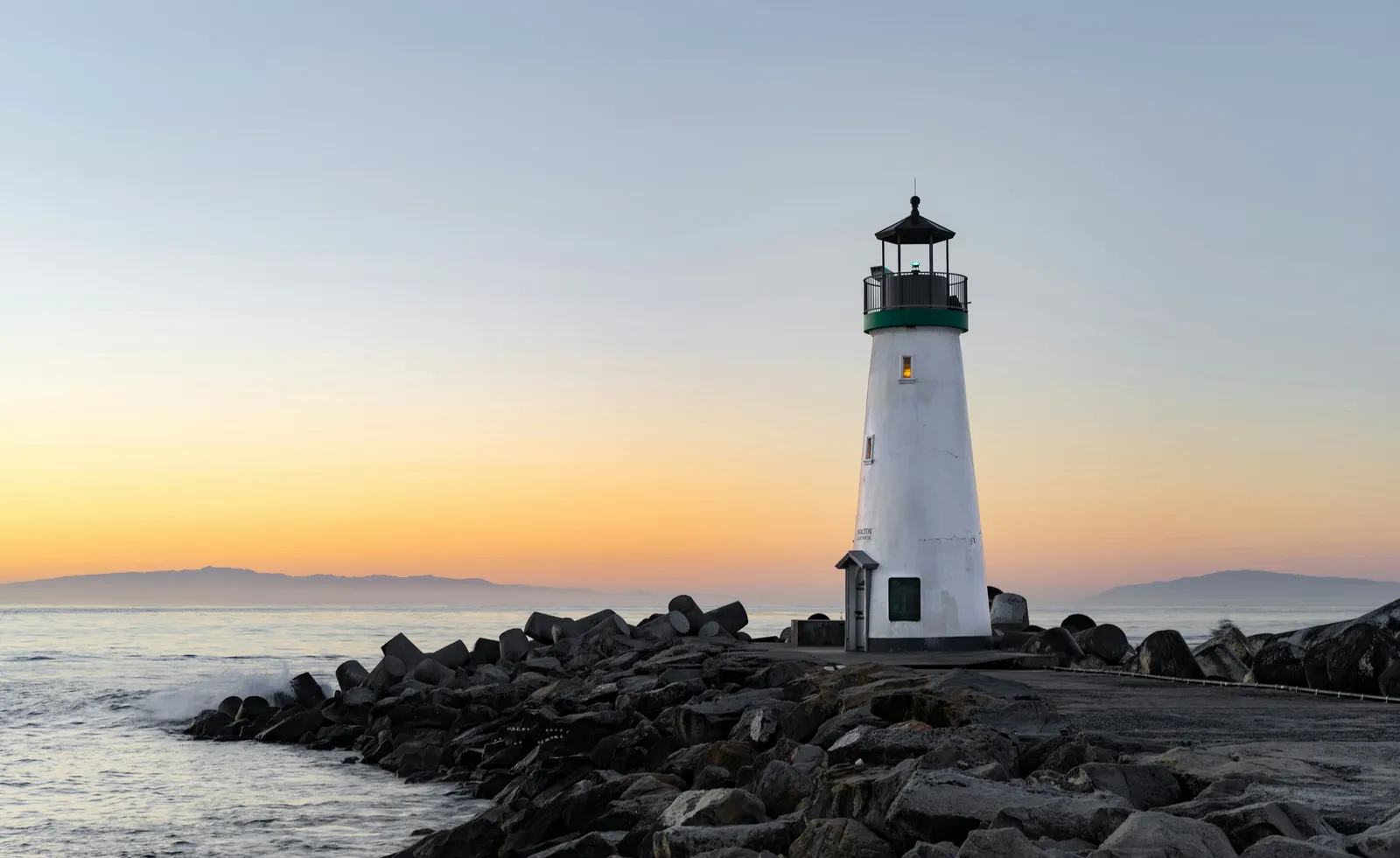 A lighthouse standing beneath a colorful evening sky