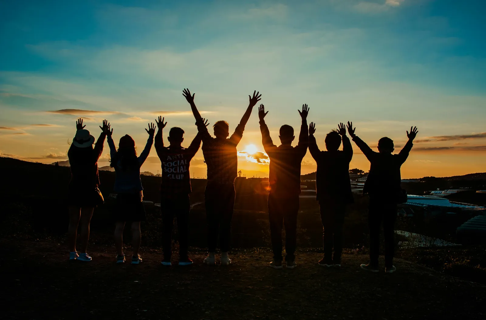 A group of young people standing together at sunset